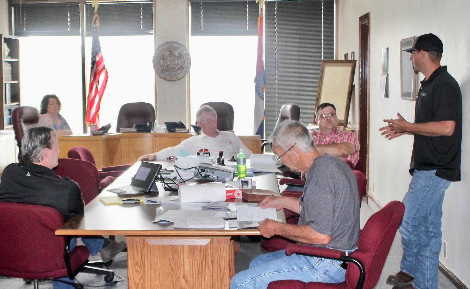 Jeremy Manning, structural engineer for Smith & Co. Engineering, standing at right, gives a presentation to the Howell County Commission of the results of his assessment of 20 local bridges being considered for repair. Listening, from left, are County Clerk Kelly Waggoner, Smith Co. engineer Bill Robison, Presiding Commissioner Mark Collins, Southern Commissioner Billy Sexton and Northern Commissioner Calvin Wood.